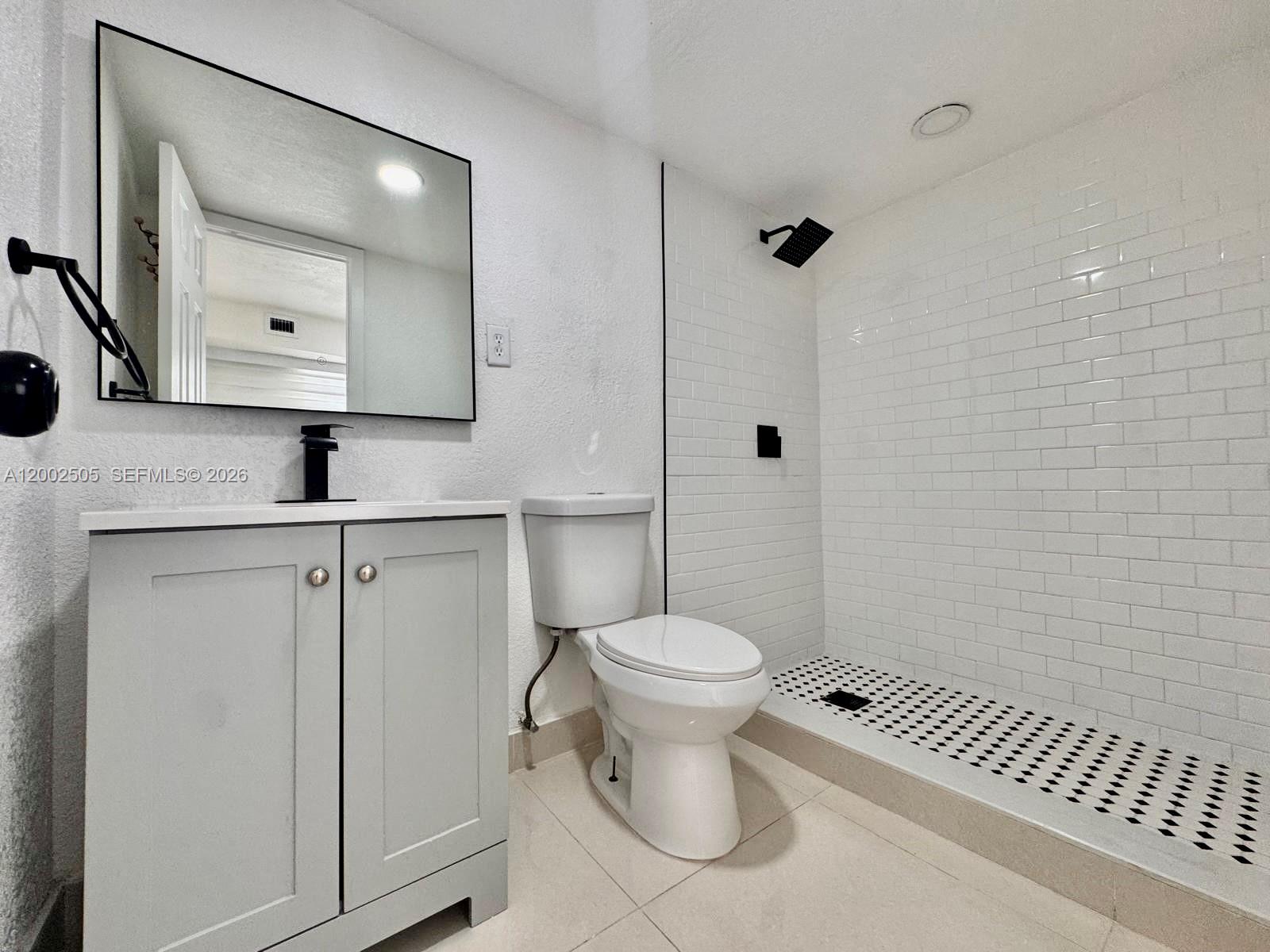 541 East 38th Street Hialeah, FL 33013 - Photo 7 of 14 a bathroom with a granite countertop toilet a sink and a mirror