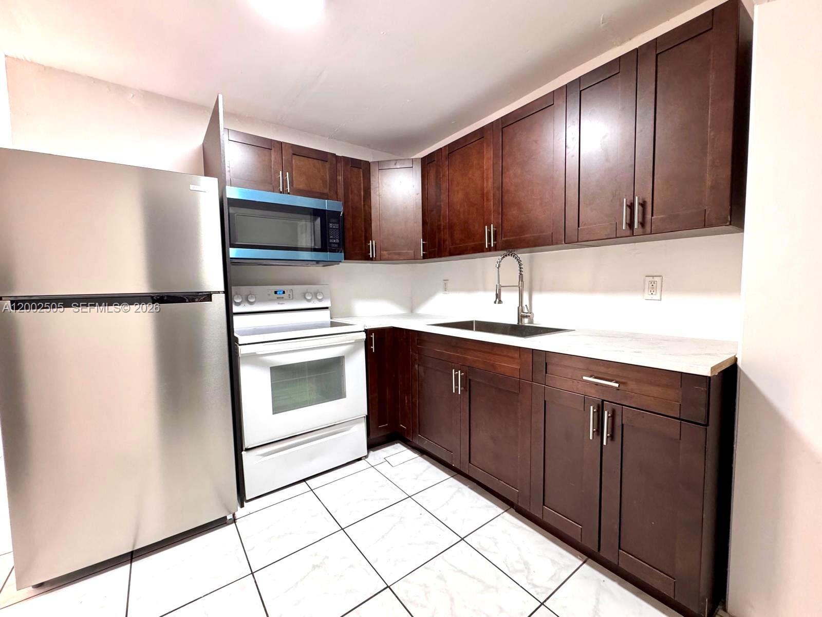 541 East 38th Street Hialeah, FL 33013 - Photo 8 of 14 a kitchen with granite countertop stainless steel appliances and wooden cabinets