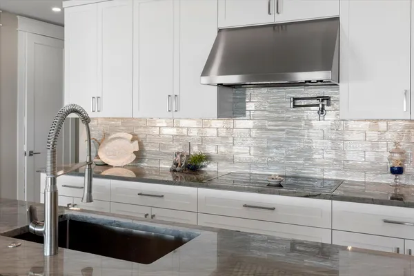 a kitchen with stainless steel appliances a refrigerator and a wooden floor