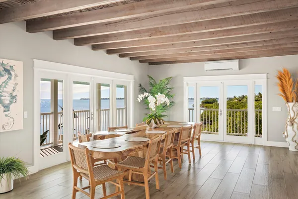 a view of a dining room with furniture large windows and wooden floor