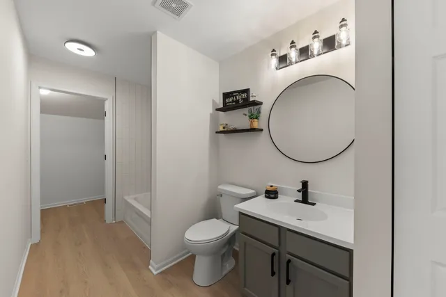 a bathroom with a toilet a sink and a mirror