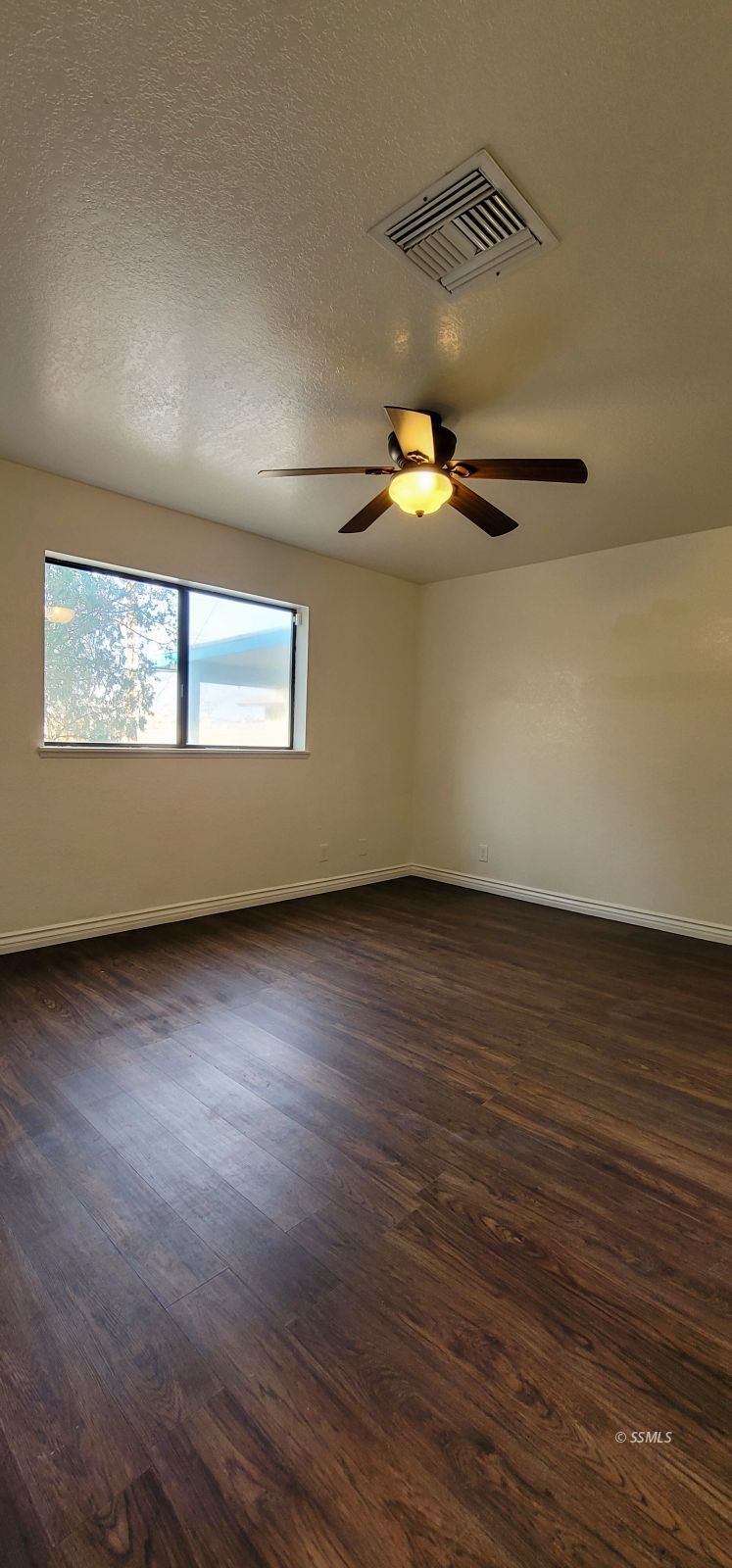 544 Weiman Avenue Ridgecrest, CA 93555 - Photo 15 of 20 an empty room with wooden floor fan and windows
