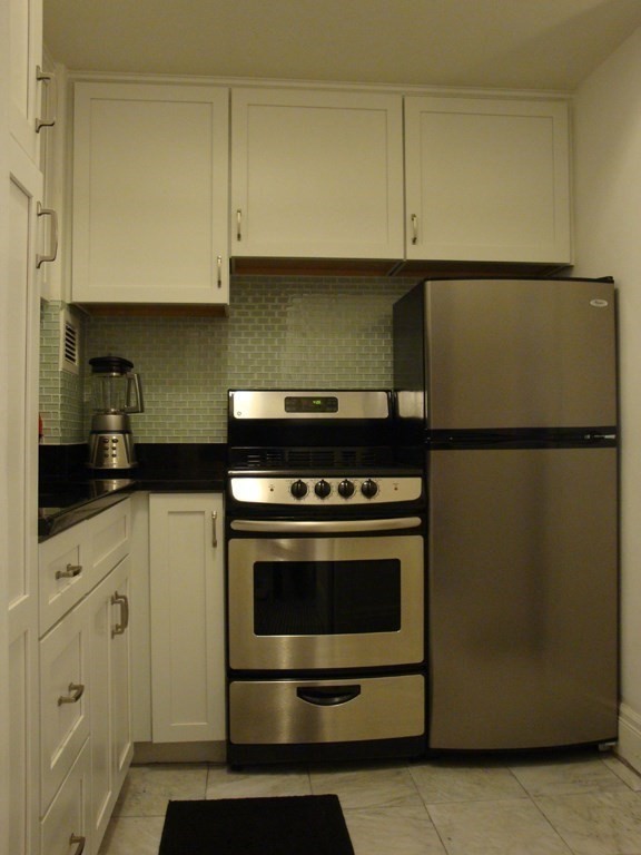 21 Beacon Street, Unit 6D Boston, MA 02108 - Photo 9 of 13 a kitchen with granite countertop cabinets and steel stainless steel appliances