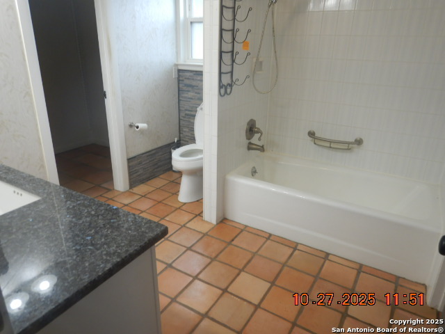 15397 Cassiano Road Elmendorf, TX 78112 - Photo 23 of 29 a spacious bathroom with a granite countertop bathtub and toilet