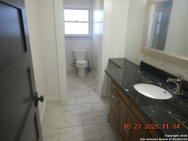15397 Cassiano Road Elmendorf, TX 78112 - Photo 26 of 29 a bathroom with a granite countertop sink and a mirror