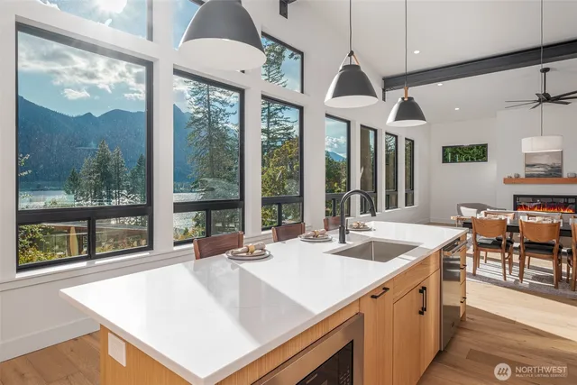 a kitchen with stainless steel appliances granite countertop a sink and a large window