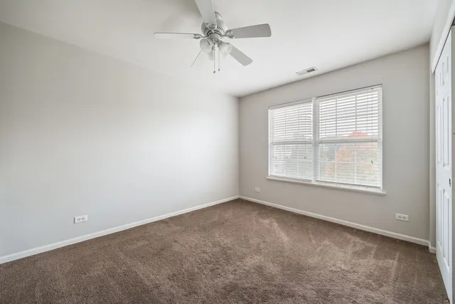 an empty room with a window and a fan