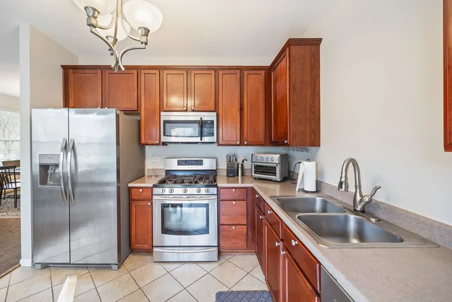 a kitchen with stainless steel appliances granite countertop a sink stove refrigerator and cabinets