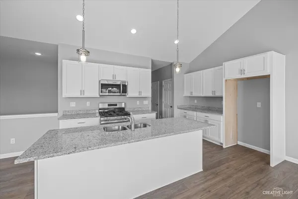 a kitchen with stainless steel appliances granite countertop a sink a stove and a refrigerator