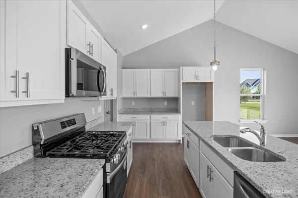 a kitchen with stainless steel appliances granite countertop a sink stove and refrigerator