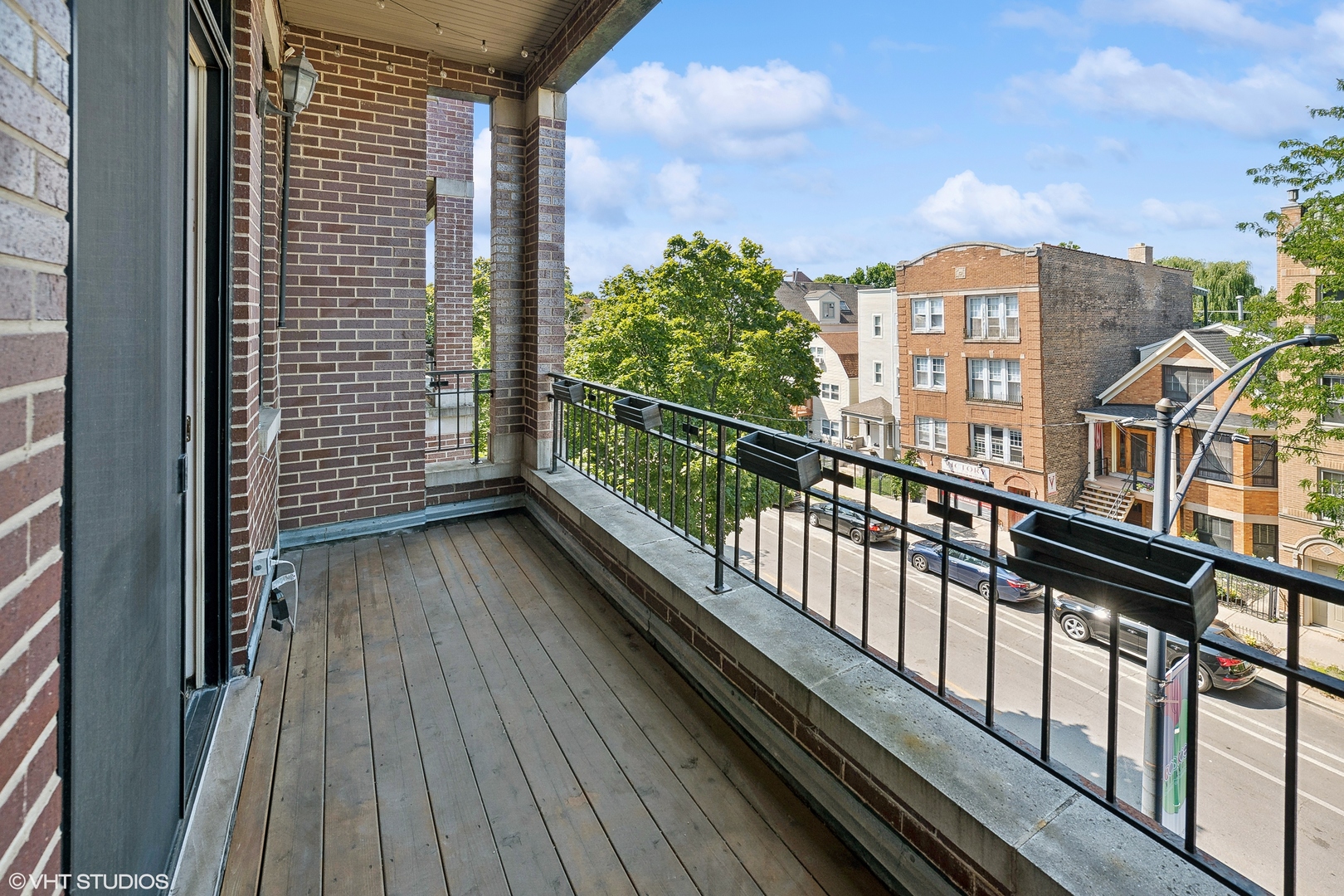 2207 West Roscoe Street, Unit 3E Chicago, IL 60618 - Photo 11 of 25 a view of balcony with wooden floor and fence