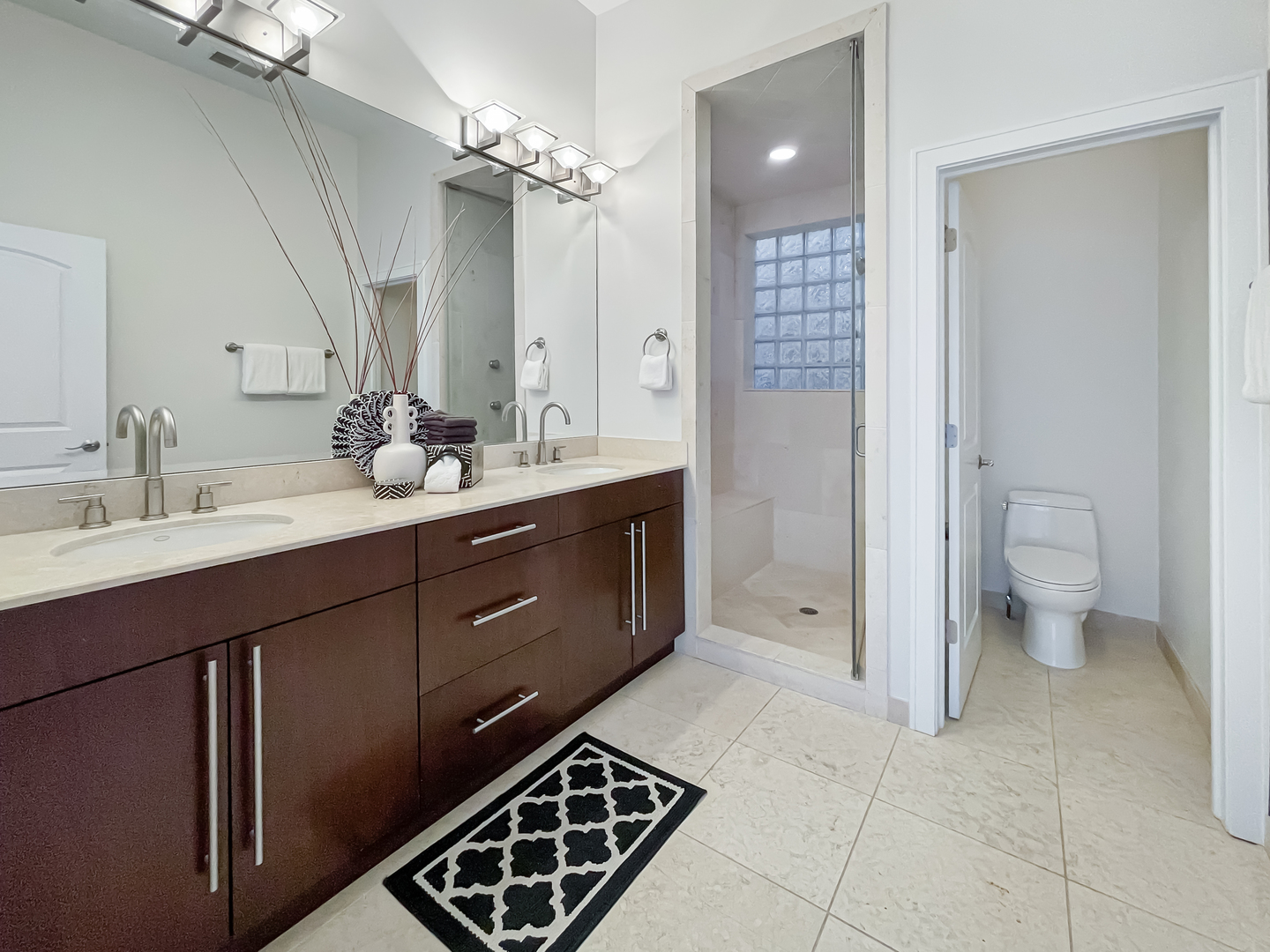 2207 West Roscoe Street, Unit 3E Chicago, IL 60618 - Photo 15 of 25 a spacious bathroom with a double vanity sink a mirror and a toilet