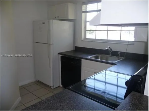 a kitchen with stainless steel appliances granite countertop a refrigerator a sink and a stove