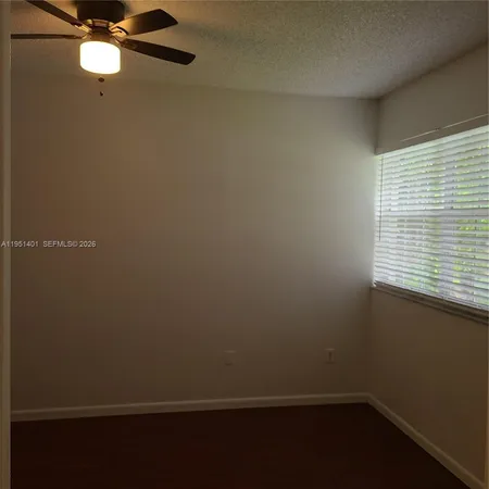 a view of a small space with wooden floor and a window