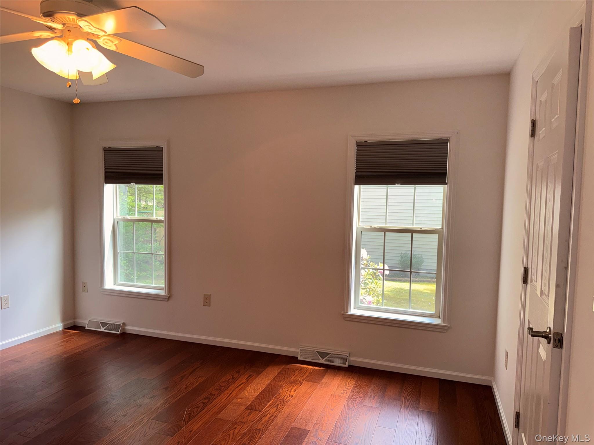 1661 Old Country Road, Unit 516 Riverhead, NY 11901 - Photo 36 of 50 an empty room with wooden floor chandelier and windows