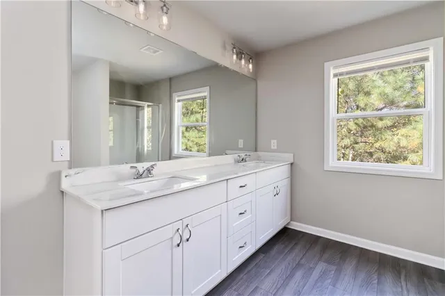 a bathroom with a granite countertop sink mirror and window