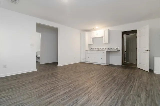 a view of a kitchen with wooden floor and a sink