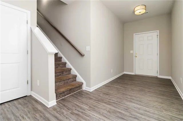 a view of a hallway with wooden floor and staircase