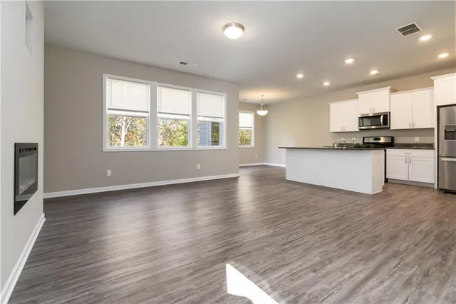 an open kitchen with a sink dishwasher stove and wooden floor