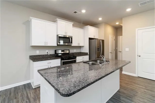 a kitchen with stainless steel appliances granite countertop a sink refrigerator and microwave