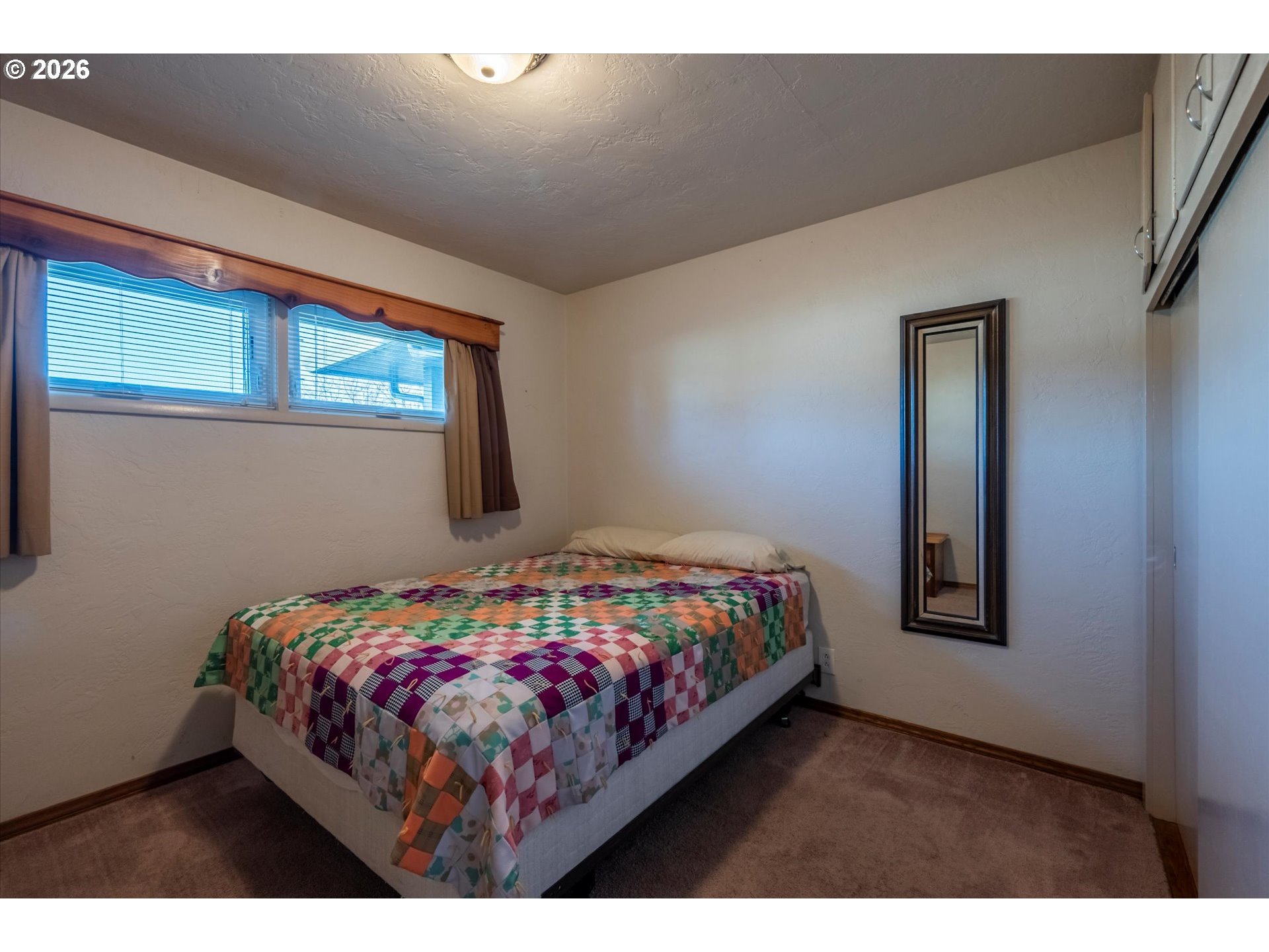 2480 Gardens Avenue Reedsport, OR 97467 - Photo 13 of 22 a bedroom with a bed lamp and a window