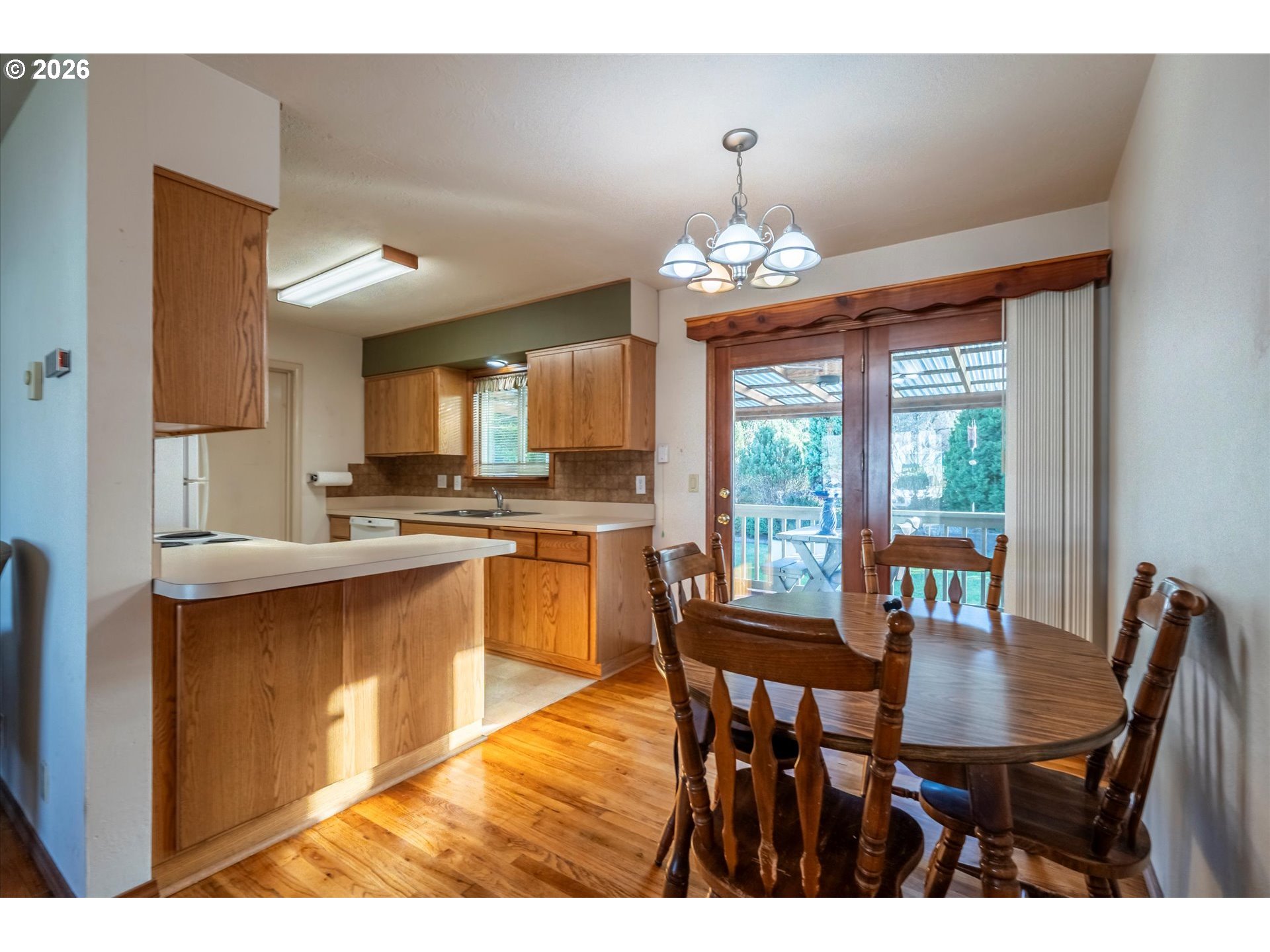 2480 Gardens Avenue Reedsport, OR 97467 - Photo 7 of 22 a view of a dining room with furniture wooden floor and chandelier