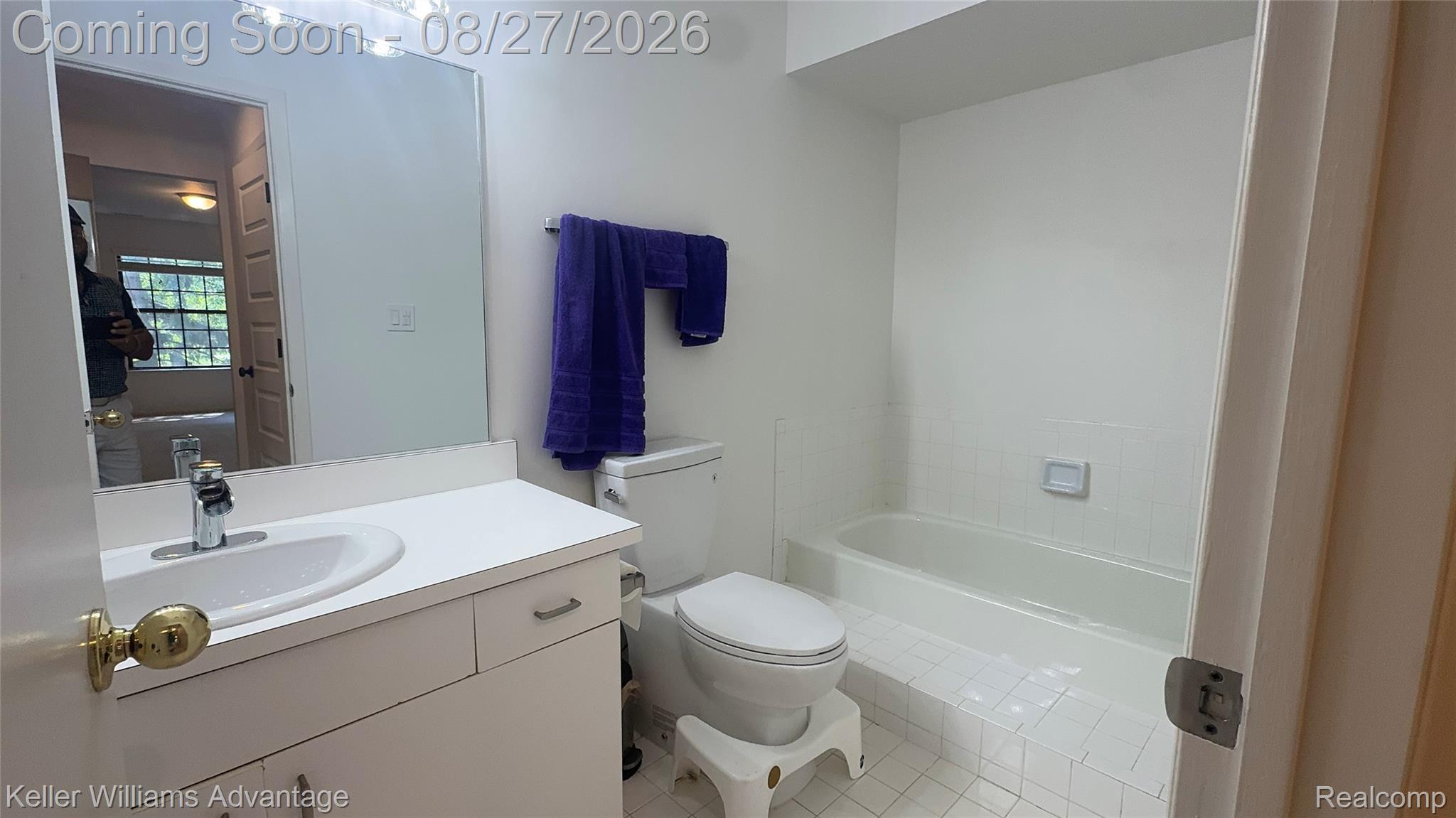 29726 Pine Ridge Circle Farmington, MI 48331 - Photo 36 of 42 Bathroom featuring a single vanity with an integrated sink, a rectangular mirror, and a built-in bathtub with tiled surround