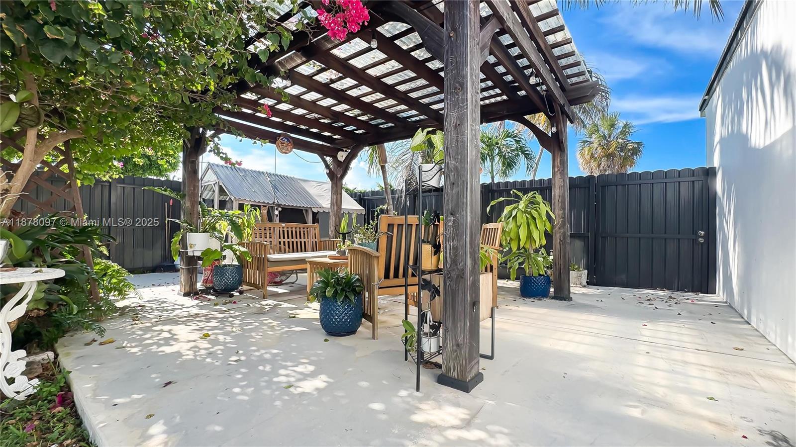 10370 Southwest 34th Street Miami, FL 33165 - Photo 8 of 47 a view of a patio with table and chairs under an umbrella with a small yard