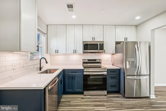 a kitchen with stainless steel appliances a refrigerator stove and sink