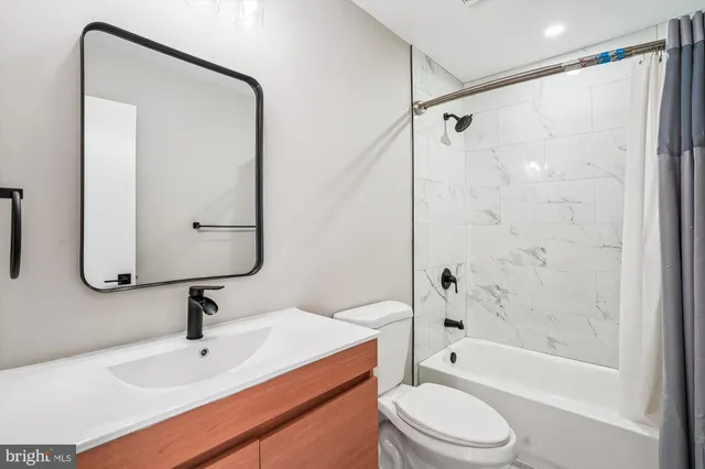 a bathroom with a sink a toilet and a mirror