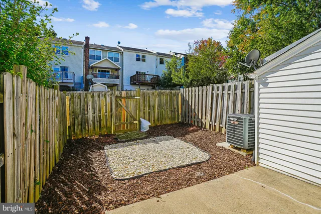 a view of a brick house with a small yard and wooden fence