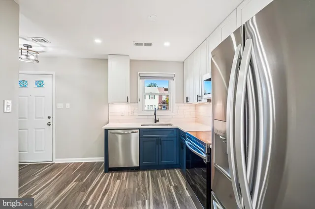 a kitchen with stainless steel appliances granite countertop a refrigerator and a sink