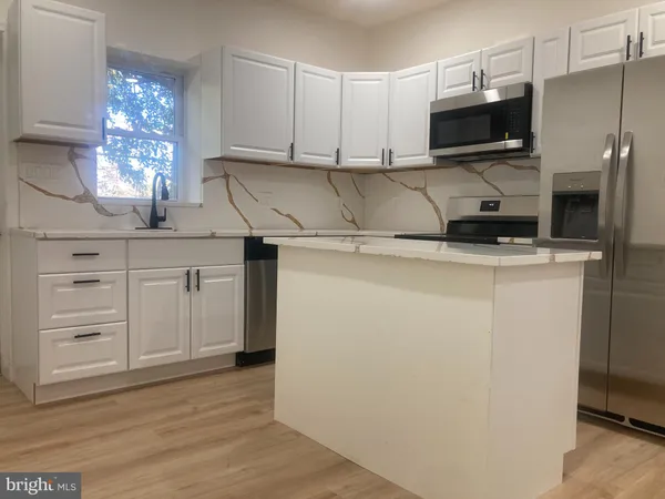 a kitchen with stainless steel appliances white cabinets and a sink