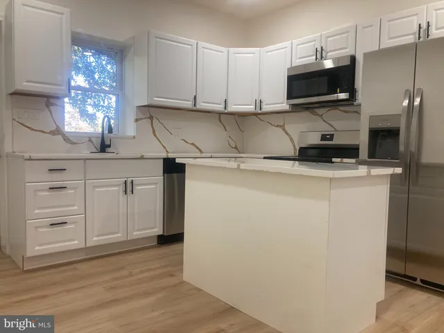 a kitchen with stainless steel appliances white cabinets and a sink