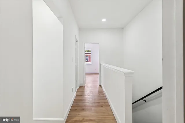 a view of a hallway with wooden floor and staircase