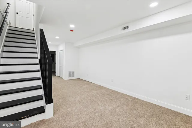 an empty room with a ceiling fan and carpet