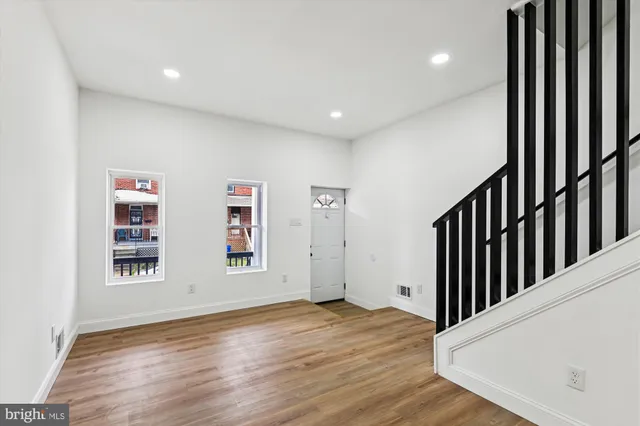 a view of a hallway with wooden floor and closet