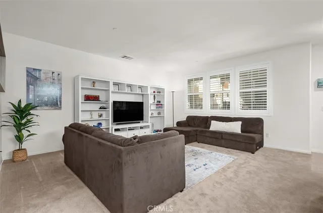 a living room with furniture a flat screen tv and a large window