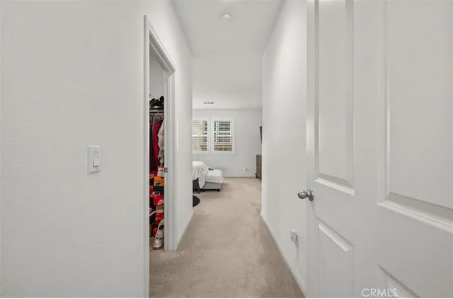 a view of a hallway with wooden floor and a bathroom