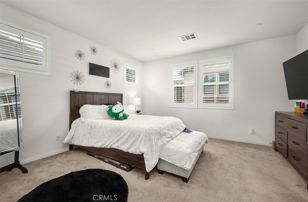 646 South Fillmore Avenue Rialto, CA 92376 - Photo 17 of 46 a bedroom with a bed and flat tv screen on the dresser