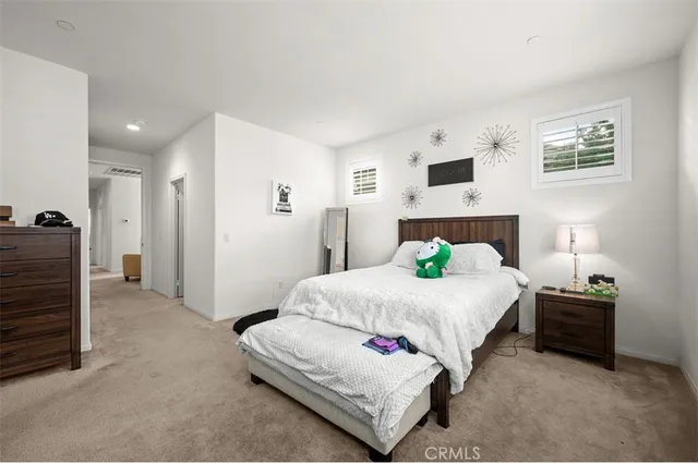 a spacious bedroom with a bed and a lamp