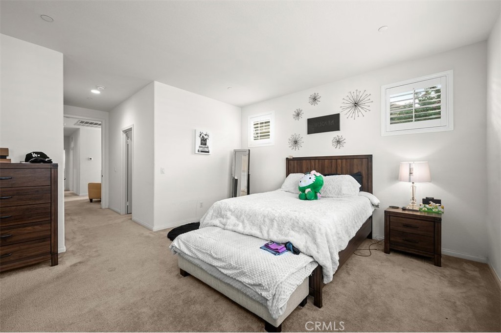 646 South Fillmore Avenue Rialto, CA 92376 - Photo 19 of 46 a spacious bedroom with a bed and a lamp