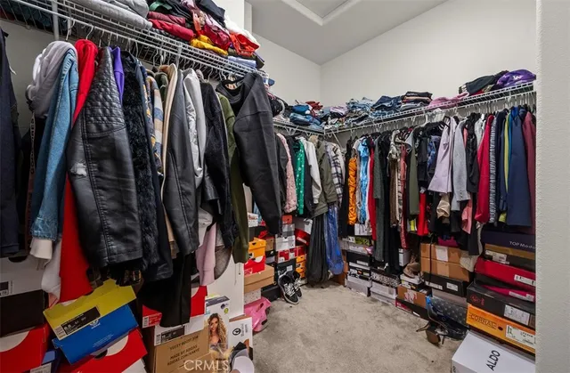 a view of walk in closet with clothes
