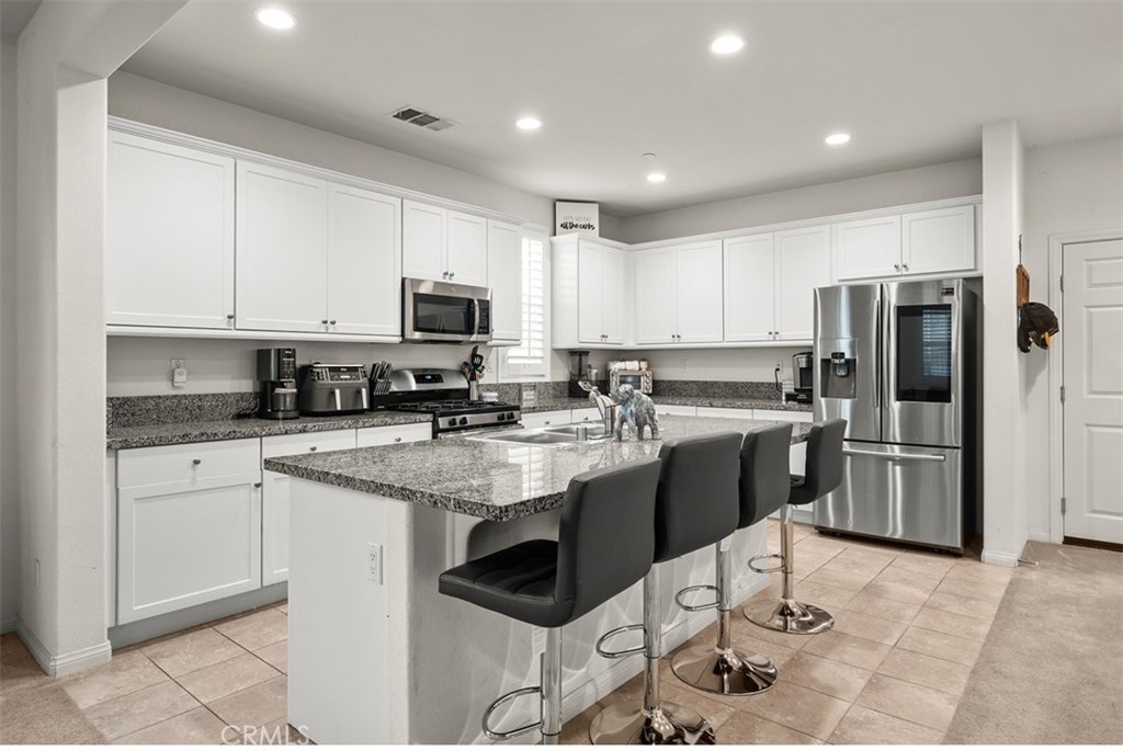 646 South Fillmore Avenue Rialto, CA 92376 - Photo 8 of 46 a kitchen with stainless steel appliances granite countertop a stove a sink a refrigerator a microwave and cabinets