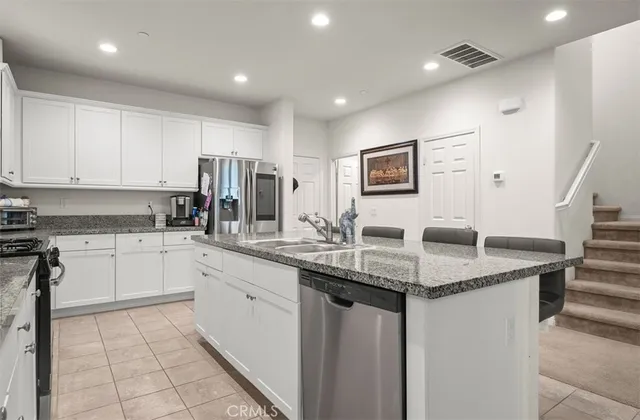 a kitchen with stainless steel appliances granite countertop refrigerator sink and cabinets