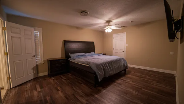 a bedroom with a bed and a flat tv screen on dresser