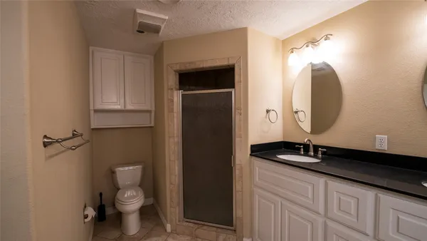 a bathroom with a granite countertop sink a toilet and a mirror