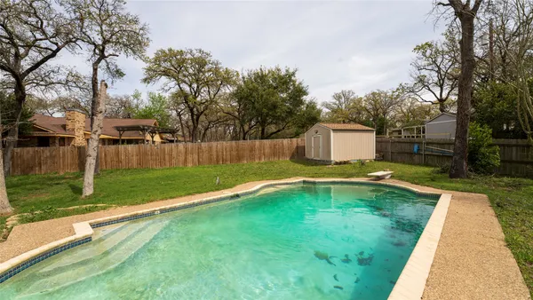 a view of a house with swimming pool and a yard