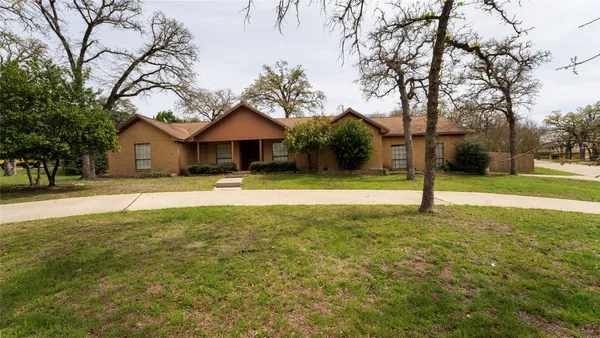 a view of a house with a yard and tree s