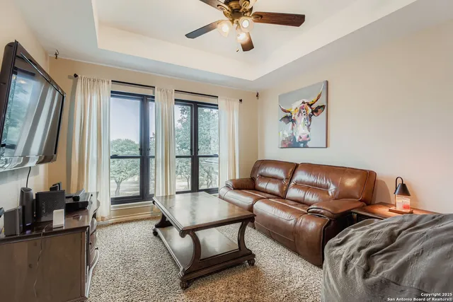 a living room with furniture a large window and flat screen tv